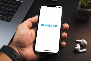 Man holding a smartphone with OnlyFans app
