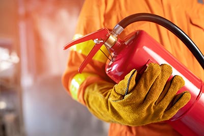 Fireman hand holding fire extinguisher. available in emergencies