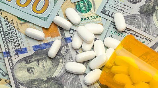 prescription drug pills on pile of money