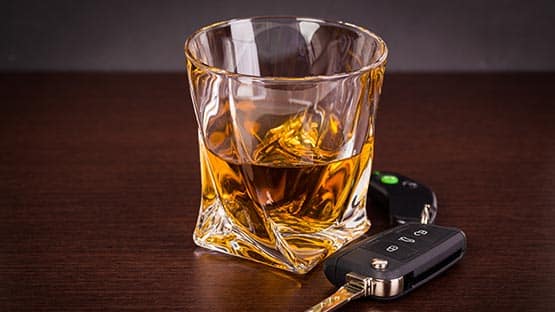 car keys beside glass of whiskey