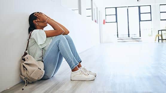 teen girl with face in hands