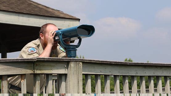 park ranger looking through viewfinder