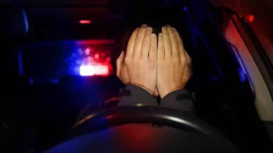 traffic stop showing man with hands over face