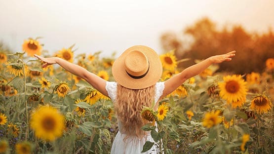 woman in hat in sunflower field