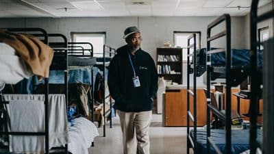 man walking between bunk beds at Valley Mission in Staunton