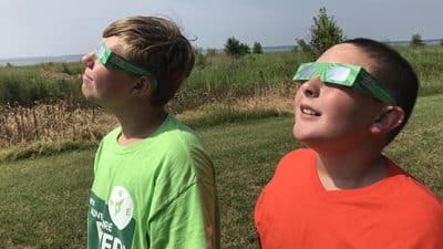 children viewing solar eclipse with viewing glasses
