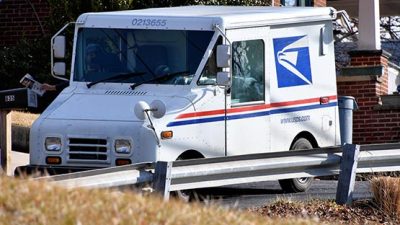 mailman delivering mail in mail truck to mailbox