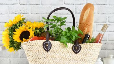 farmers market bag with sunflowers, tomatoes, bread, vegetables, wine