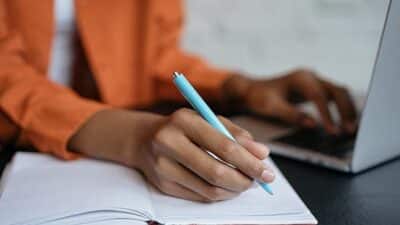 college student taking notes writing essay