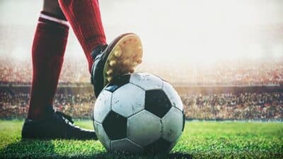 feet of soccer player tread on soccer ball for kick-off in the s