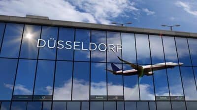 Airplane landing at Dusseldorf Germany airport mirrored in termi
