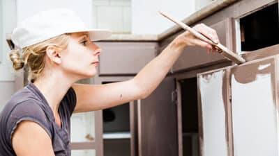 woman painting cabinet drawer slides