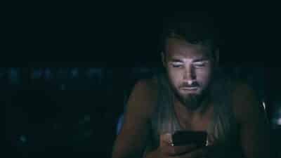 night bed man in bed playing game sweeptstakes insomnia phone addiction